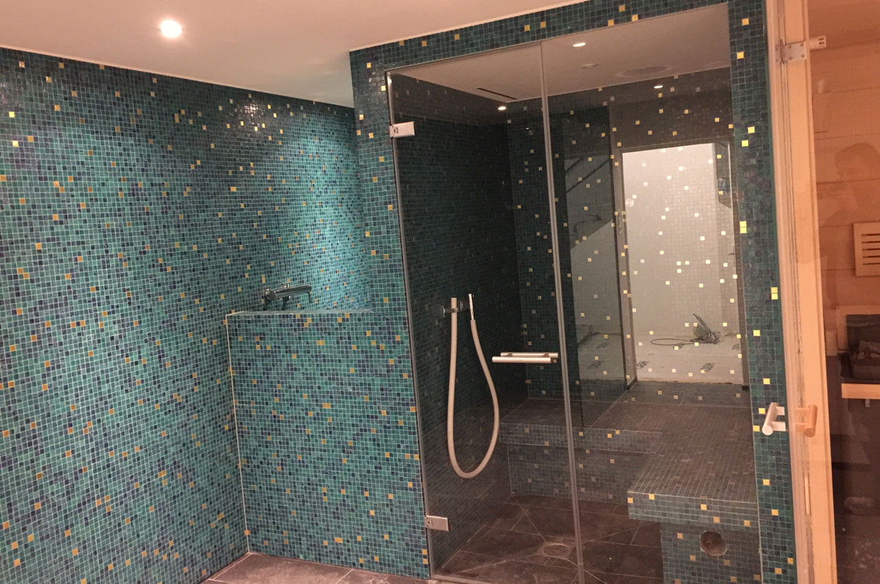 Badzimmer mit Mosaiksteinen und Duschkabine